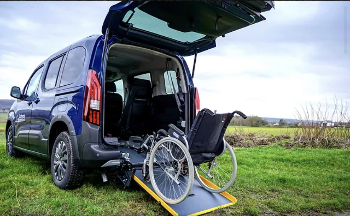 Une chaise roulante sur une rampe d'accès d'un véhicule PMR